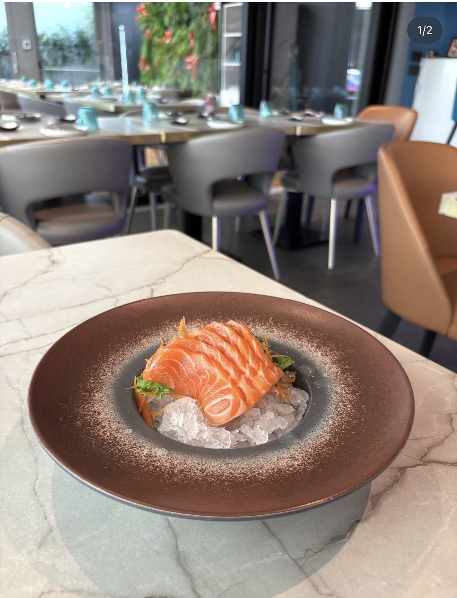 La sala di MIOMI con un piatto di sashimi in primo piano